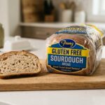 A commercial package of Franz Gluten Free Sourdough bread on a wooden cutting board.